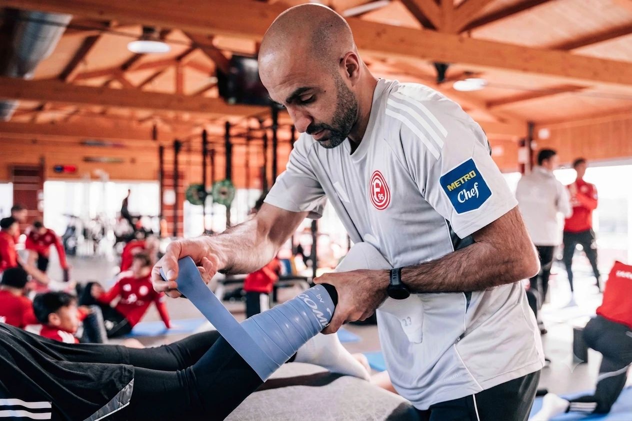 Fais Al Mami leitet im Training eine Übung mit dem Widerstandsband an